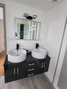 a bathroom with two sinks and a mirror at Maison de charme in Benoîtville