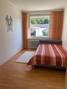 a bedroom with a bed and a window at Ferienhaus direkt an der Luhe in Winsen