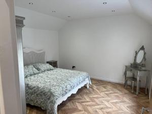 een slaapkamer met een bed en een tafel met een spiegel bij West Loch Farm Bothy in Peebles