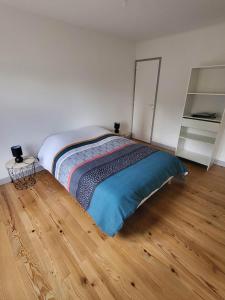 een slaapkamer met een bed en een houten vloer bij Maison de charme in Benoîtville