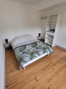 een slaapkamer met een bed en een houten vloer bij Maison de charme in Benoîtville