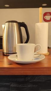 a cup on a plate next to a tea kettle at Zen Museu do Bonsai in Sintra