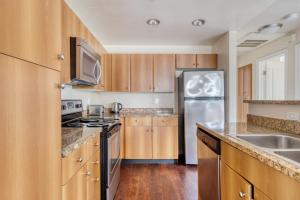 a kitchen with wooden cabinets and a stainless steel refrigerator at San Jose 1BR w Pool Gym nr Caltrain SFO-766 in San Jose
