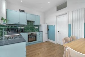 a kitchen with blue and white appliances and a table at Clinton Place in Seaford