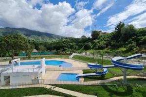 una gran piscina con un parque acuático en Apartasol con jacuzzi SantaFe en Santa Fe de Antioquia