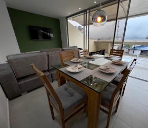 comedor con mesa, sillas y sofá en 601S Penthouse moderno con Parqueo Incluido, en Ibagué