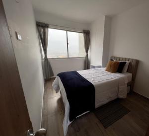 1 dormitorio con cama y ventana grande en 601S Penthouse moderno con Parqueo Incluido, en Ibagué