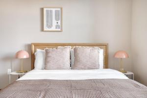 a bedroom with a large bed with two pink lamps at Burlingame 1BR w gym wd rooftop nr Caltrain SFO-1056 in Burlingame