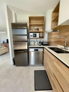 a kitchen with a stainless steel refrigerator and a sink at Mereani flat brand new condo in the center of Papeete in Papeete