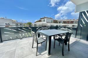 a table and chairs on the balcony of a building at Mereani flat brand new condo in the center of Papeete in Papeete