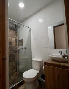 y baño con aseo, ducha y lavamanos. en 601S Penthouse moderno con Parqueo Incluido, en Ibagué