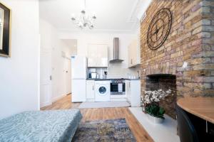 uma sala de estar com lareira de tijolos e uma cozinha em flat in south west London 1 min to the station em Londres