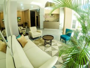 Hotel Viaggiatore في كوتشابامبا: غرفة معيشة مع أريكة بيضاء وكراسي