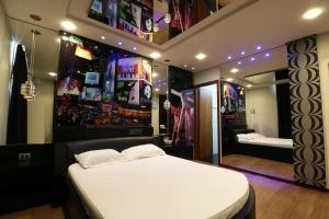 ein Schlafzimmer mit einem großen weißen Bett und einem Spiegel in der Unterkunft Liberty Motel in Saltinho