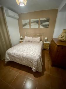 ein Schlafzimmer mit einem Bett und zwei Gemälden an der Wand in der Unterkunft Casa Rural Villa Briar in Olvera