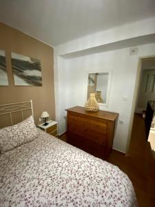 una camera con letto, cassettiera e specchio di Casa Rural Villa Briar a Olvera