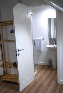 a bathroom with a white door and a sink at Modern 3-Bed Home with Large Parking Space a Short Walk to Cardiff Bay or City Centre Contractor Friendly" in Cardiff