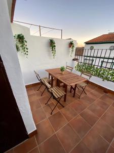 un patio con tavolo e sedie in legno sul balcone. di Casa Rural Villa Briar a Olvera