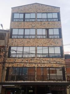 Edificio de ladrillo antiguo con ventanas y balcón en Apartamento Ángel Namaste, en Bello