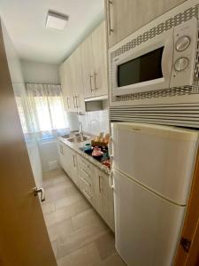 a kitchen with a white refrigerator and a microwave at CASA GODOY in Cáceres