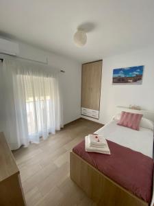 a bedroom with a large bed and a large window at CASA GODOY in Cáceres