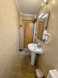 een badkamer met een wastafel, een spiegel en een toilet bij CASA GODOY in Cáceres