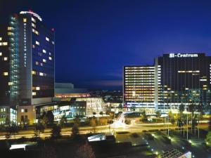 a city lit up at night with tall buildings at 1 Zimmer Appartement im SI Centrum Stuttgart in Stuttgart