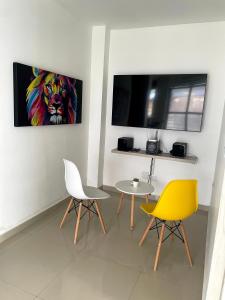 a room with two chairs and a table and a painting of a lion at APARTA HOTEL Y TERRAZA SAMANES in Florida