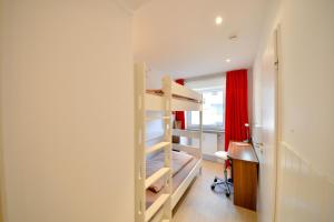 a bedroom with a bunk bed and a desk in a room at Haus Poseidon - Wohnung 1 1 in Wangerooge