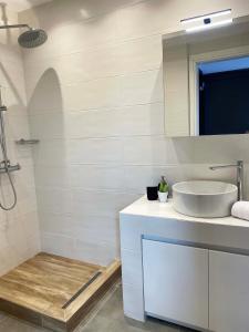 ein weißes Badezimmer mit einem Waschbecken und einem Spiegel in der Unterkunft Casa al Mare in Nea Roda