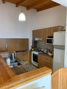 a kitchen with wooden cabinets and stainless steel appliances at Espacio Alem in Comodoro Rivadavia