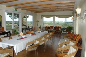 a dining room with a long table and chairs at Landsitz Kapellenhöhe, Hotel Garni in Wiedenbrügge