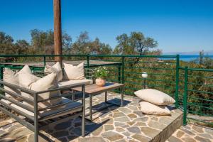 a patio with a bench and a table with pillows at Villa Levanda (Loggos Paxos) in Longós