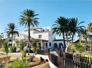 a white house with palm trees in front of it at Jardines de la Mata Boutique Beach in Mojácar