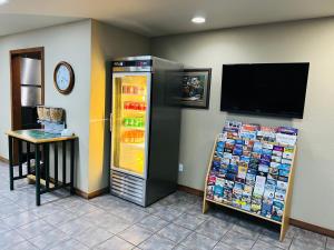 a store with a refrigerator and a tv on a wall at Cattle country lodge in Stroud
