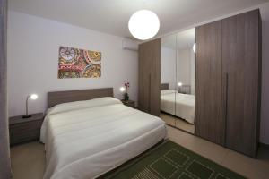 a bedroom with a large white bed and a mirror at Residence Rapisardi by RECEPTIO in Catania