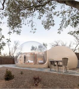 two domed buildings with a table in a garden at Zielo de Levante in Tirig
