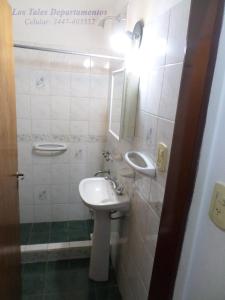 y baño con lavabo y espejo. en Los Tales Departamentos en Colón