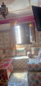 sala de estar con sofá y ventana en Dar LBAHJA 2, en Ouzoud