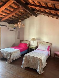 1 dormitorio con 2 camas y mesa con lámpara en Habitación Azul triple con gran jardín !! en San Isidro