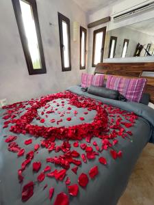 a bed covered in red rose petals in the shape of a heart at Sueños Tulum in Tulum
