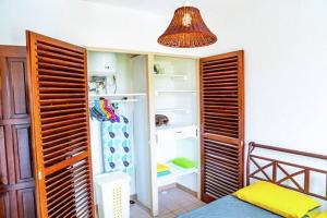 a bedroom with a closet with an open refrigerator at Bel appartement T2 * Netflix * Terrasse* Parking in Kourou