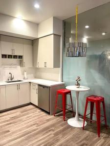 uma cozinha com dois bancos vermelhos e uma mesa branca em Jack London square stylish luxury 1BD apartment em Oakland