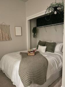Un dormitorio con una cama blanca con una cesta. en Jack London square stylish luxury 1BD apartment en Oakland