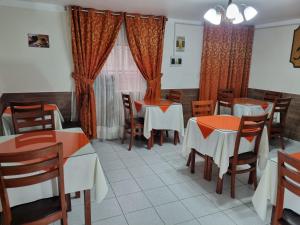 uma sala de jantar com mesas, cadeiras e cortinas em Hotel Los Nogales em Cajamarca