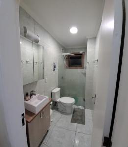 a bathroom with a toilet and a sink and a shower at Apartamento espaçoso e impecável in Bento Gonçalves