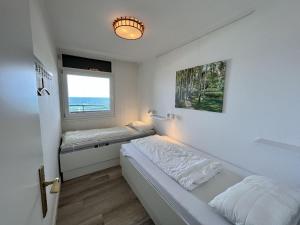 Un dormitorio pequeño con una cama y una ventana. en Strandhotel-56, en Dahme
