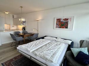 Un dormitorio con una cama y una mesa y una cocina. en Strandhotel-56, en Dahme