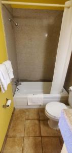 uma casa de banho com uma banheira branca e um WC. em Deluxe Inn Jasper em Jasper