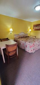 um quarto de hotel com uma cama, uma mesa e cadeiras em Deluxe Inn Jasper em Jasper